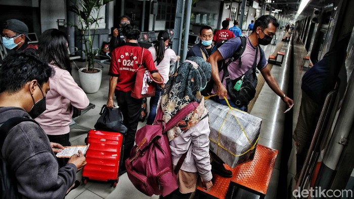 Ratusan penumpang bersiap menaiki kereta api jarak jauh di kawasan Stasiun Pasar Senen, Jakarta Pusat, Senin (20/12).