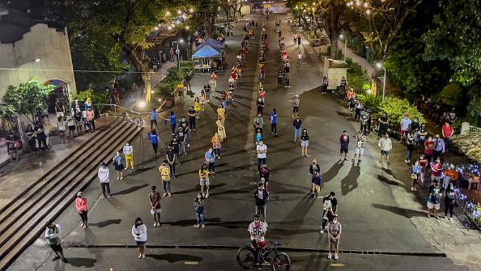 Simbang Gabi, Tradisi Misa Sebelum Fajar di Filipina MANILA, PHILIPPINES - DECEMBER 20: Churchgoers wearing facemasks light candles after attending a pre-dawn mass at a church on December 20, 2021 Paranaque, Metro Manila, Philippines. Pre-dawn masses, called