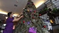 Pekerja menghias pohon Natal dengan lampu hias di Quest Hotel Darmo, Surabaya, Jawa Timur, Senin (20/12/2021). ANTARA FOTO/Didik Suhartono  
