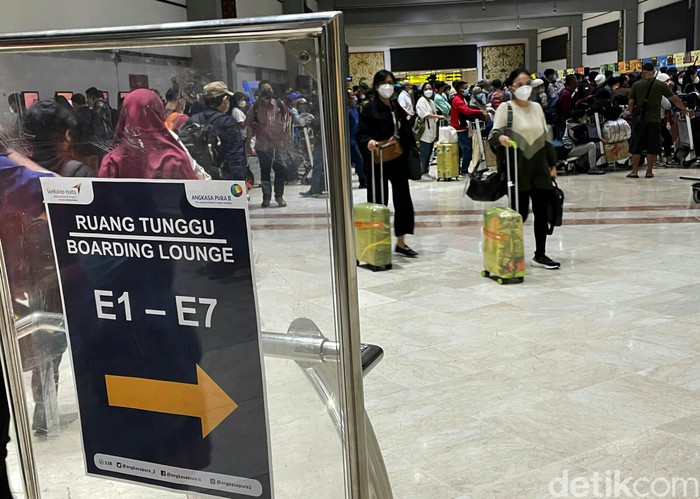 Suasana penumpang pesawat membludak di Bandara Soekarno-Hatta, Tangerang, Provinsi Banten. Menjelang masa libur Natal 2021 dan tahun baru 2022, masyarakat kembali dikejutkan dengan terdeteksinya COVID-19 varian Omicron di Indonesia.