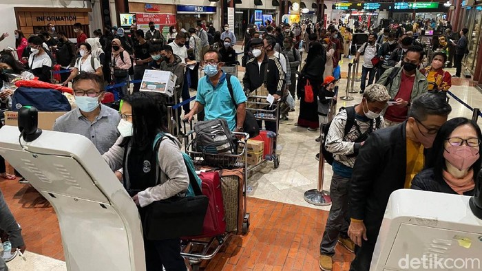 Suasana penumpang pesawat membludak di Bandara Soekarno-Hatta, Tangerang, Provinsi Banten. Menjelang masa libur Natal 2021 dan tahun baru 2022, masyarakat kembali dikejutkan dengan terdeteksinya COVID-19 varian Omicron di Indonesia.