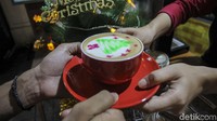 Menggunakan teknik pembuatan Latte Art untuk menggambar pohon cemara di minuman Cappucino spesial menyambut hari raya Natal.  