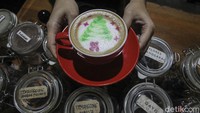 Barista menunjukan minuman Cappucino bergambar tema Natal di warung kopi Cerita Kopi Mukidi, Yogyakarta, Senin (20/12/2021).