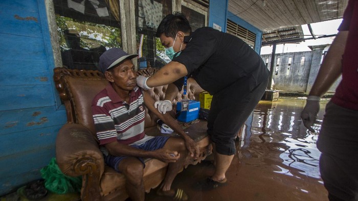 Banjir merendam Kabupaten Banjar, Kalimantan Selatan. Meski banjir pelayan di Mapolsek Martapura dan proses vaksinasi tetap berjalan.