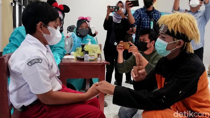 Pemkot Solo memulai vaksinasi anak usia 6 hingga 11 tahun hari ini. Tokoh karakter kartun pun hadir untuk hibur anak-anak yang akan disuntik vaksin COVID-19.