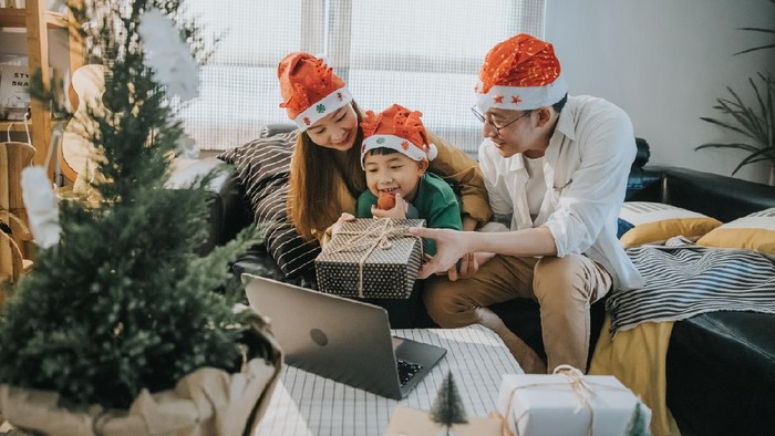 Asian Chinese couple decorating Christmas tree at home ready for Christmas celebration