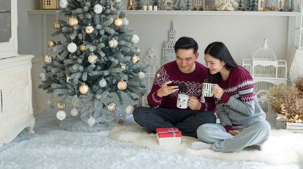 Kartu ucapan natal Asian Chinese couple decorating Christmas tree at home ready for Christmas celebration