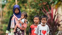 Seorang ibu menggendong anaknya yang ikut mengungsi.