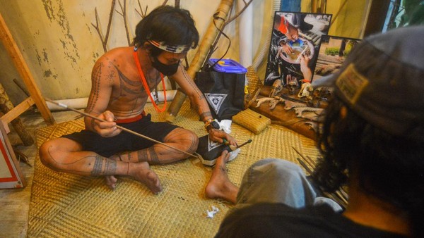 Seorang Sipatiti (seniman tato Mentawai), Alexander Kora Sakoddobat (kiri), mendemonstrasikan pembuatan tato tradisional Mentawai di Padang, Sumatera Barat, Senin (20/12/2021). Seorang Sipatiti (seniman tato Mentawai), Alexander Kora Sakoddobat (kiri), mendemonstrasikan pembuatan tato tradisional Mentawai di Padang, Sumatera Barat, Senin (20/12/2021).