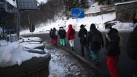 Para migran dari Italia menuju Prancis berjalan menyusuri jalan pegunungan menuju perbatasan Prancis-Italia.