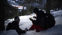 Migran Afghanistan Ali Rezaie melihat peta di ponselnya saat ia dan Sayed Hamza melakukan perjalanan melalui Pegunungan Alpen Prancis-Italia untuk mencapai tempat perlindungan migran di Briancon, Prancis.
