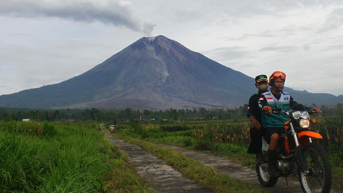 Awan panas guguran keluar melalui bukaan aliran lava baru Gunung Semeru terpantau dari Desa Supiturang, Pronojiwo, Lumajang, Jawa Timur, Selasa (21/12/2021). Pusat Riset Aplikasi Penginderaan Jauh Lapan - Badan Riset dan Inovasi Nasional (BRIN) mencatat Gunung Semeru mengalami perubahan bentuk di wilayah kawah hingga lereng bagian tenggara akibat aktivitas vulkanik berupa luncuran awan panas guguran. ANTARA FOTO/Ari Bowo Sucipto/rwa.