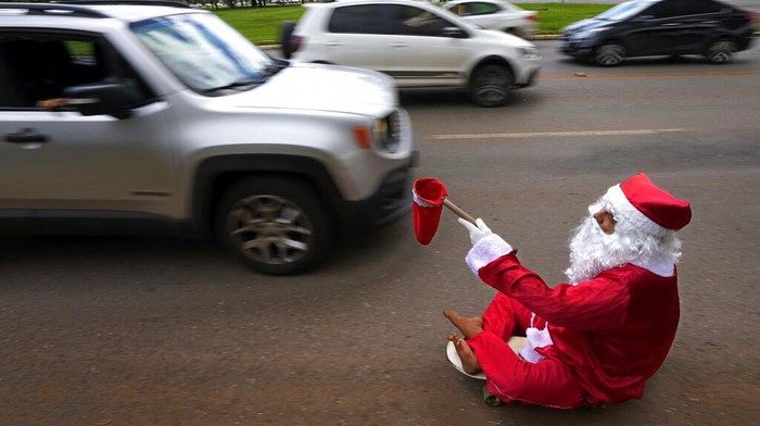 Bukan Bagi Hadiah, 'Santa' Ini Malah Minta-minta di Jalanan Brasil Jose Ivanildo, who lost the use of his legs due to infantile paralysis, uses a skate board as he begs for money at a traffic light dressed as Santa Claus in Brasilia, Brazil, Tuesday, Dec. 21, 2021. The 48-year-old, known as