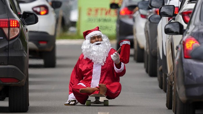 Bukan Bagi Hadiah, 'Santa' Ini Malah Minta-minta di Jalanan Brasil Jose Ivanildo, who lost the use of his legs due to infantile paralysis, uses a skate board as he begs for money at a traffic light dressed as Santa Claus in Brasilia, Brazil, Tuesday, Dec. 21, 2021. The 48-year-old, known as