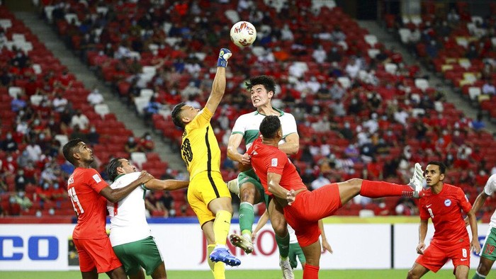 Hassan Sunny of Singapore, third left, and Elkan William Tio Baggott of Indonesia compete for the ball during the AFF Suzuki Cup 2020 semi-final first leg soccer match between Singapore and Indonesia in Singapore, Wednesday, Dec. 22, 2021. (AP Photo/Suhaimi Abdullah)