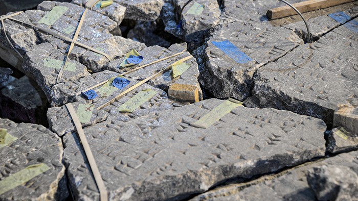 This picture taken on December 14, 2021 shows a fragment of an artefact bearing cuneiform inscriptions being reconstructed and reassembled at the Mosul Museum in Iraqs northern city. - In the damaged Mosul Museum, Iraqis supported by French restoration workers sort through the fragments of 2,500-year-old remains destroyed by jihadists, part of efforts aiming for reconstruction. (Photo by Zaid AL-OBEIDI / AFP)