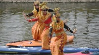 Pegiat olahraga stand up paddle (dayung berdiri) melakukan tarian di atas papan perahu saat parade kebaya stand up paddle di PIK 2, Tangerang, Banten, Sabtu (18/12/2021). Kegiatan yang digelar oleh Maliko Stand Up Paddle itu dalam rangka menyambut Hari Ibu. ANTARA FOTO/Hafidz Mubarak A