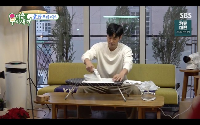 Siwon menggunakan sapu tangan yang berbeda setiap harinya. Dia memastikan semuanya sudah kering dan mulai menyetrika. Pemain drama Korea Work Later Drink Now itu meletakkan meja setrika di atas meja yang lebih panjang dan mendengarkan berita dari ponselnya. Foto: dok. SBS