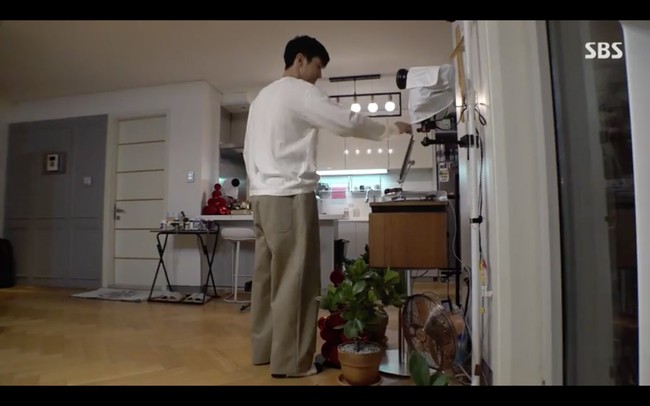 Setelah selesai menyetrika, Siwon Super Junior memutar playlist lagu jazz dari tablet yang dia letakkan di sebuah meja di dekat pintu keluar menuju balkon. Foto: dok. SBS