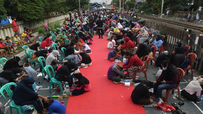 Seorang ibu menangis sambil memeluk anaknya saat aksi cuci kaki ibu massal di Jakarta, Rabu (22/12/2021). Aksi yang diikuti sebanyak 500 peserta itu bertujuan untuk meningkatkan rasa cinta kasih kepada ibu, khususnya dalam rangka memperingati Hari Ibu. ANTARA FOTO/Akbar Nugroho Gumay/rwa.