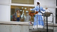 Para pasien anak-anak dan keluarga mereka menyaksikan penampilan para siswa penyelamat darurat Rusia yang mengenakan kostum Santa Klaus dan Snegurochka atau Snow Maiden dalam rangka menyambut Natal di luar rumah sakit.