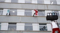 Sejumlah siswa penyelamat darurat Rusia mengenakan kostum Santa Klaus dan Snegurochka atau Snow Maiden memanjat gedung sebuah rumah sakit di Moskow untuk menghibur para pasien anak-anak di RS tersebut.