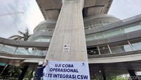 Petugas memasang spanduk pengumuman uji coba Halte CSW.
