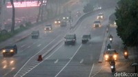 Pengendara sepeda motor dan mobil berhati-hati saat melintasi Jl Sudirman. 