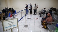 Petugas mengecek persyarakat bepergian kepada calon penumpang bus.