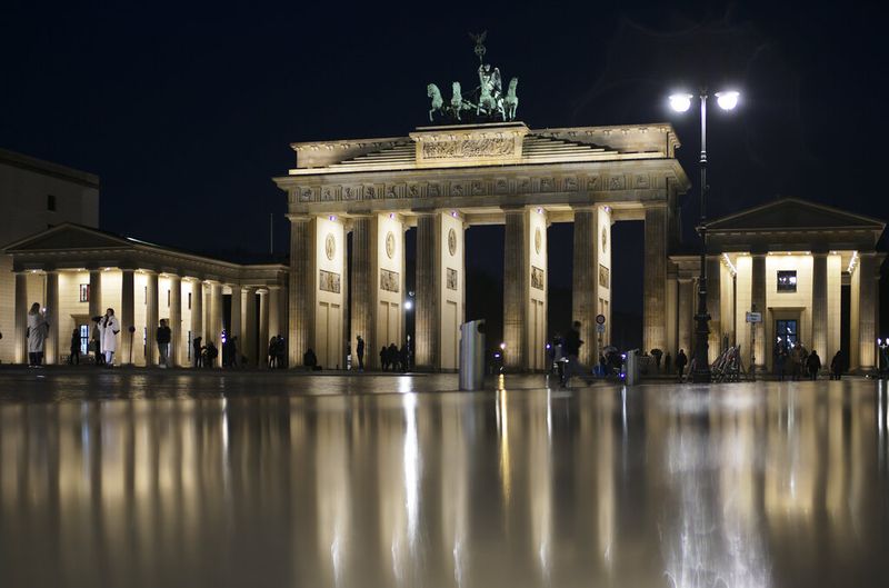 Orang-orang berkumpul di depan landmark Jerman Gerbang Brandenburg di Berlin, Jerman, Kamis, 18 November 2021. Badan pengendalian penyakit Jerman, The Robert Koch Institute, melaporkan 65.371 kasus harian baru, memecahkan rekor 24 jam sebelumnya dan melanjutkan tren naik yang telah diperingatkan para ahli selama berminggu-minggu. (Foto AP/Markus Schreiber)