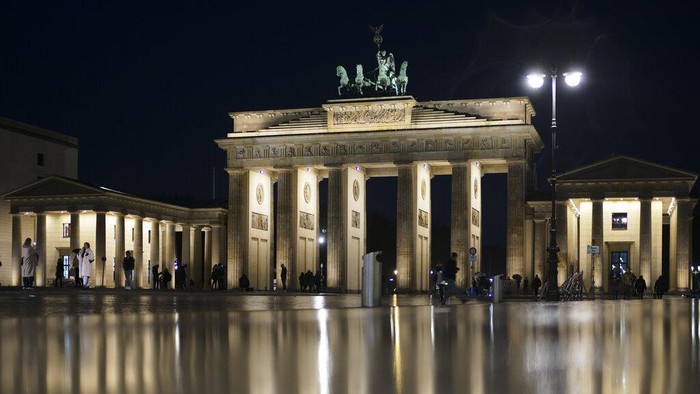 Kota-kota di Dunia yang Batalkan Perayaan Tahun Baru Gegara Omicron Orang-orang berkumpul di depan landmark Jerman Gerbang Brandenburg di Berlin, Jerman, Kamis, 18 November 2021. Badan pengendalian penyakit Jerman, The Robert Koch Institute, melaporkan 65.371 kasus harian baru, memecahkan rekor 24 jam sebelumnya dan melanjutkan tren naik yang telah diperingatkan para ahli selama berminggu-minggu. (Foto AP/Markus Schreiber)