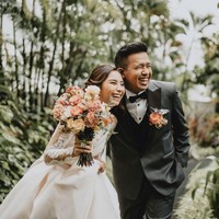 Sementara Joshua Suherman memakai setelan jas yang didominasi abu-abu, kemeja putih, dan dasi kupu-kupu berwarna hitam. Tersemat bunga oranye pada saku setelan rancangan SAS Designs tersebut. Foto: dok. Instagram thebridestory