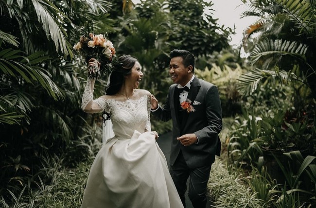 Raut bahagia terpancar dari foto pernikahan Joshua Suherman dan Clairine Clay. Keduanya tidak menikah di akhir pekan seperti pasangan pada umumnya. Pelantun lagu ‘Diobok-obok’ itu mengaku menggelar acara pemberkatan di hari Rabu agar tidak ketinggalan menonton Liga Inggris. Foto: dok. Instagram cynthiatan__