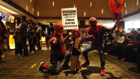 Relawan beraksi layaknya tokoh Spider-Man di film yang hendak mengeluarkan jaring dari tangannya.