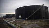 Pekerja PT Pertamina Hulu Rokan menaiki anak tangga tangki pengumpul produksi minyak (Tank Farm) di Blok Rokan, Dumai, Riau, Rabu (22/12/2021).