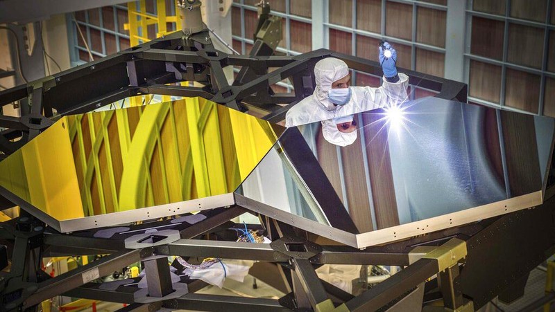 Dalam foto 29 September 2014 yang disediakan oleh NASA, Insinyur Optik Teleskop Luar Angkasa James Webb Larkin Carey memeriksa dua segmen cermin uji pada prototipe di ruang bersih raksasa Goddard Space Flight Center di Greenbelt, Md. Webb akan mencoba untuk melihat kembali ke dalam. waktu 13,7 miliar tahun, hanya 100 juta tahun setelah Big Bang yang membentuk alam semesta saat bintang-bintang aslinya terbentuk. (Chris Gunn/NASA via AP)