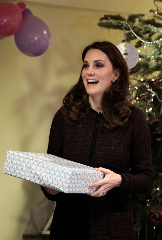 Datang ke pesta Natal Desember 2017 yang diadakan untuk anak-anak terdampak kebakaran, Kate Middleton memilih busana tweed coat berwarna ungu gelap dari brand Seraphine. Pada Natal 2017, Kate tengah mengandung anak ketiganya yaitu Pangeran Louis yang lahir pada April 2018. Foto: Getty Images