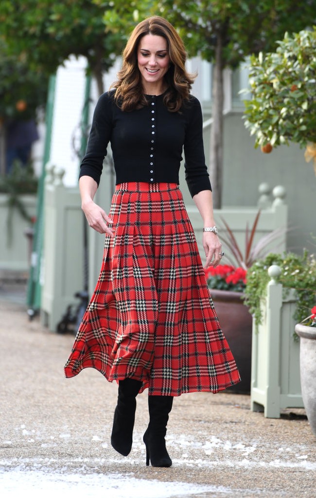 Merayakan Natal 2018 bersama keluarga tentara Inggris, Kate Middleton tampil stylish dengan rok tartan dari desainer Emilia Wickstead dan cardigan cashemere berpotongan pendek. Foto: Getty Images