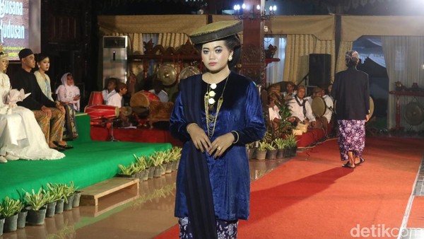 Ada juga busana tata kaji. Model memakai alas kaki selop, busana rok panjang, mengenakan mahkota, memakai giwang berbentuk babon angkrem, hiasan di leher mengenakan kalung tretes berlian, hingga sepasang gelang. (Dian Utoro Aji/detikTravel) Ada juga busana tata kaji. Model memakai alas kaki selop, busana rok panjang, mengenakan mahkota, memakai giwang berbentuk babon angkrem, hiasan di leher mengenakan kalung tretes berlian, hingga sepasang gelang. (Dian Utoro Aji/detikTravel)