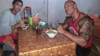 Ditraktir bakso sama om ini semoga dapat customer yang baik kek gini, tulis seorang pria yang mengedit fotonya jadi makan bareng Dwayne Johnson. Foto: Instagram @lucugila.id