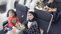 Menikmati berbagai hidangan lezat di pesawat juga membuat anak-anak Shandy tetap nyaman dalam perjalanan yang panjang. Dengan sabar, Shandy bahkan menyuapi anak bungsunya. Foto: Instagram/shandypurnamasari