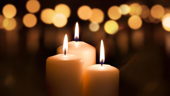 Three candles on dark background