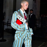 Iris Law tampil boyish dengan setelan blazer dan celana garis-garis lengkap dengan dasi. Ia tampil sambil membawa majalah Vogue. IniFoto: dok. Instagram/@lirisaw