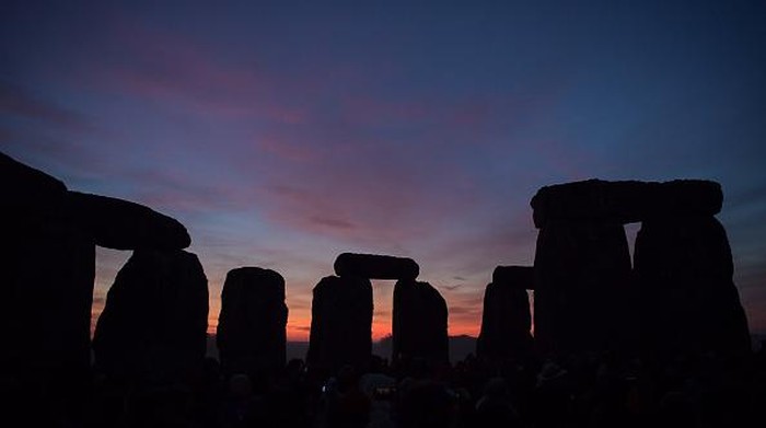 WILTSHIRE, ENGLAND - DECEMBER 22: Participants enjoy the sunset at Stonehenge on December 22, 2021 in Amesbury, United Kingdom. Along with the live stream, English Heritage, which manages the site, has allowed visitors into the event for the first time since the pandemic. The event is claimed to be more important in the pagan calendar than the summer solstice because it marks the re-birth of the Sun for the New Year. (Photo by Finnbarr Webster/Getty Images)