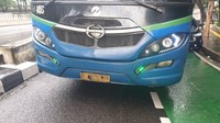 Mobil minibus tersebut terjepit di antara trotoar dengan bus APTB. Belum diketahui penyebab kejadian serempetan ini.