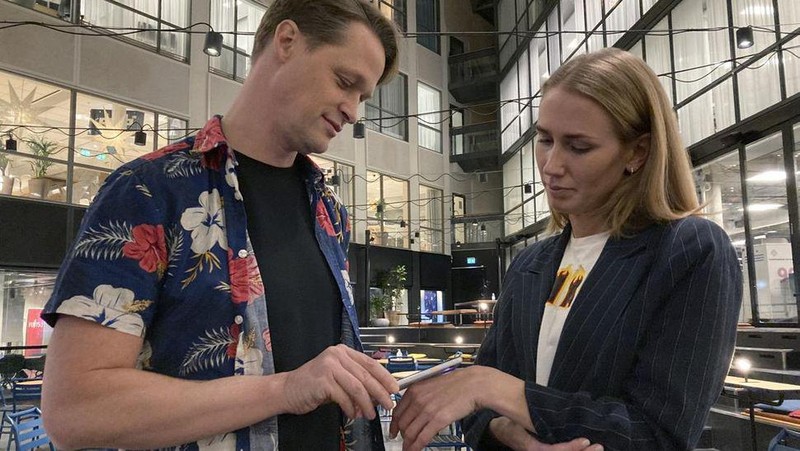 Amanda Back, marketing manager at Epicenter Stockholm, scans with a smartphone a microchip developed by the DSruptive Subdermals company and implanted in her hand to reveal her health pass in Stockholm on December 20, 2021. - Swedish company DSruptive Subdermals has come up with a microchip that can be inserted under the skin so that users can carry their Covid passports in their arm. (Photo by Viken KANTARCI / AFP) / TO GO WITH AFP STORY by Viken KANTARCI