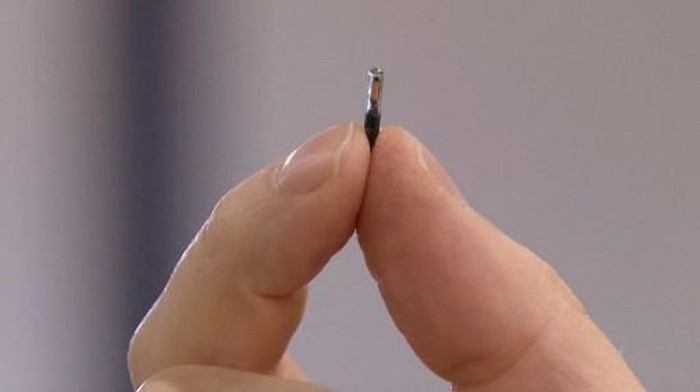 Amanda Back, marketing manager at Epicenter Stockholm, scans with a smartphone a microchip developed by the DSruptive Subdermals company and implanted in her hand to reveal her health pass in Stockholm on December 20, 2021. - Swedish company DSruptive Subdermals has come up with a microchip that can be inserted under the skin so that users can carry their Covid passports in their arm. (Photo by Viken KANTARCI / AFP) / TO GO WITH AFP STORY by Viken KANTARCI