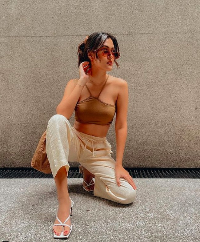 Potret stylish Rebecca Tamara dengan tank top dan celana putih. Di banyak kesempatan, Rebecca memilih warna-warna baju neutral.Foto: dok. Instagram/@rebeccatamara