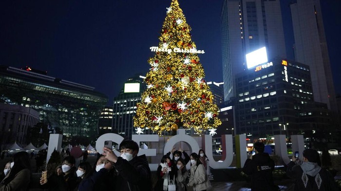 A couple takes a selfie with an illuminated Christmas decorations on the Eve of Christmas in Seoul, South Korea, Friday, Dec. 24, 2021. (AP Photo/Ahn Young-joon)