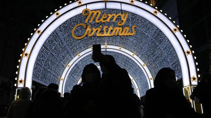 A couple takes a selfie with an illuminated Christmas decorations on the Eve of Christmas in Seoul, South Korea, Friday, Dec. 24, 2021. (AP Photo/Ahn Young-joon)